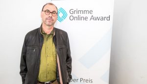 Rüdiger Braun, Autor von "Das Geheimnis des Groove", vor einem Rollup des Grimme Online Award bei der Bekanntgabe der Nominierungen 2018. Foto: Rainer Keuenhof / Grimme-Institut